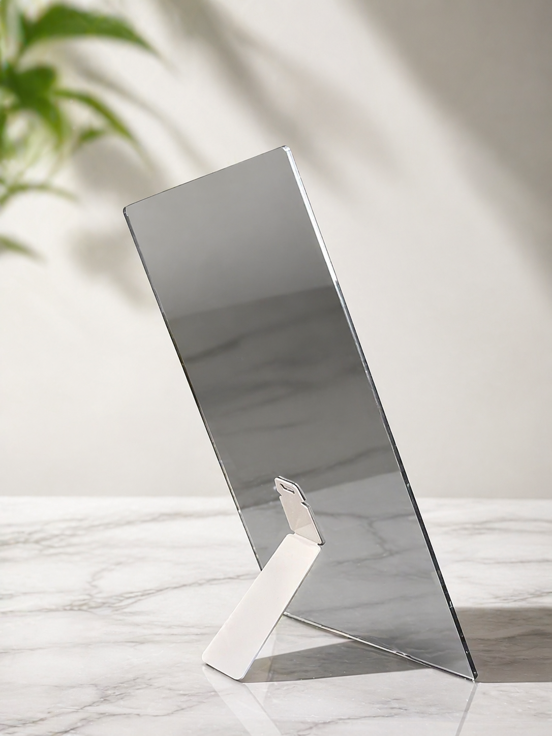 Borderless aluminum photo panel with family portrait, displayed on marble surface with rear support stand